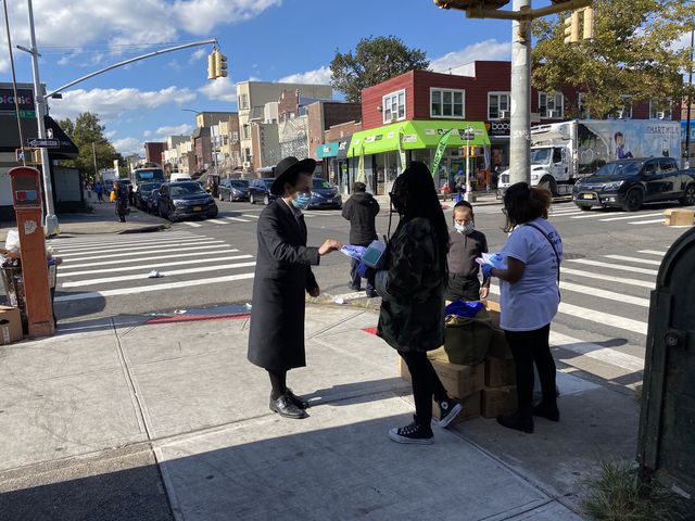 Test & Trace Corps volunteers handing out masks on 13th Avenue on Wednesday
